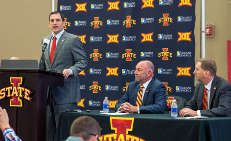 Steve Prohm speaks at a podium with Steven Leath and Jamie Polla