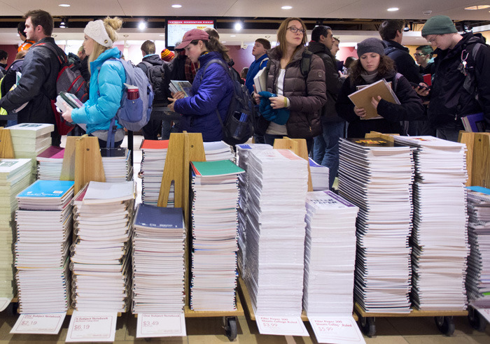 Students in line behind stacks of notebooks