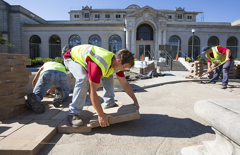 Workers install pavers in the MU fountain's plaza