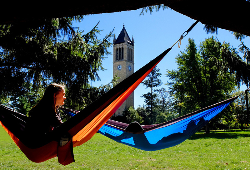 Two female students hang out in hammocks near the campanile