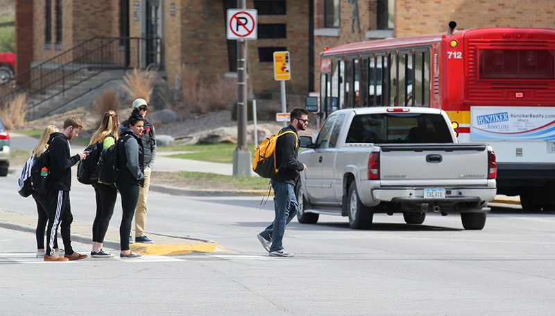students collect on the Lincoln Way median as traffic passes