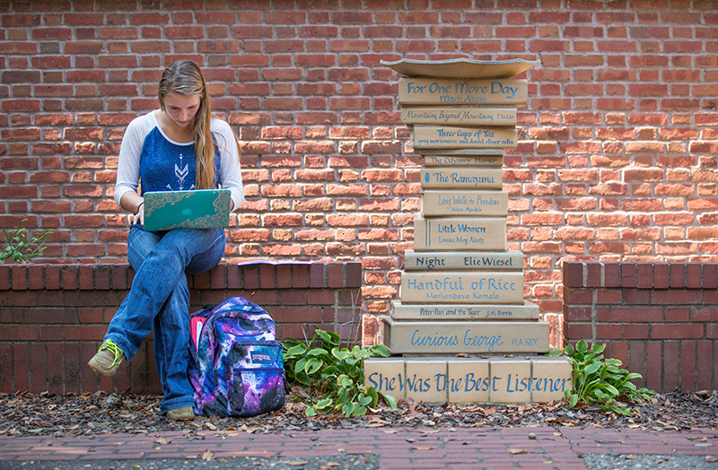 Female student studies in outdoor courtyard
