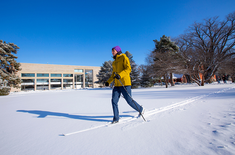 Male student cross country skis south of Parks Library