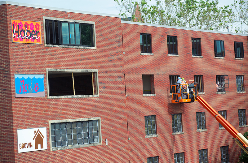 workers remove old windows from Helser Hall