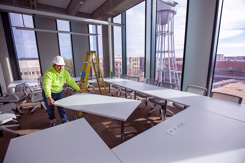 worker moves conference table into place