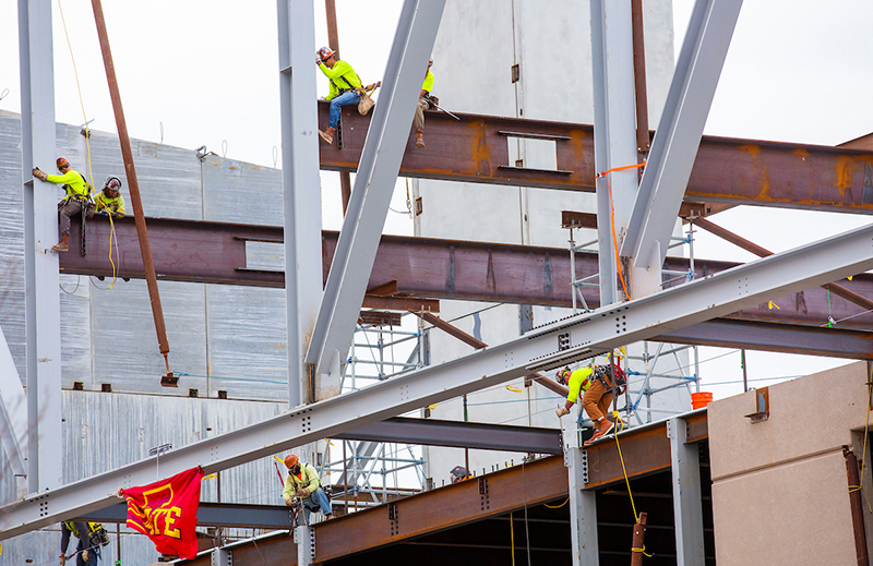 Welders connect the first truss points to the building