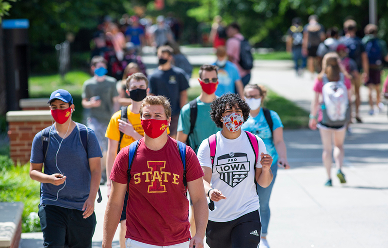 Masked students walk on central campus