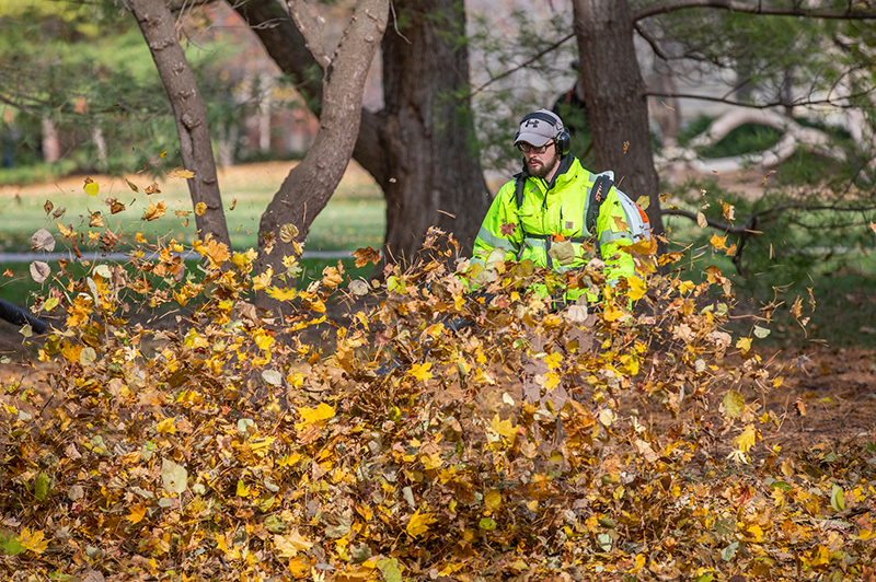 Employee Donovan Snodgrass blows leaves east of Pearson