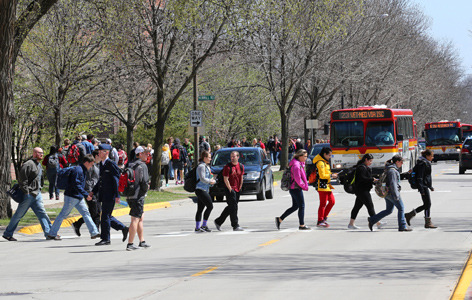 A line of students cross Osborn Drive as CyRide buses make stops