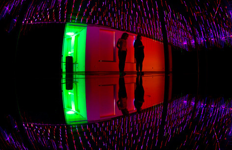 Laser filaments surround visitors viewing the exhibit