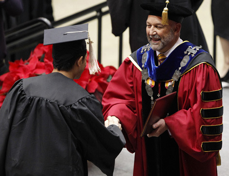 President Steven Leath congratulates a male graduate