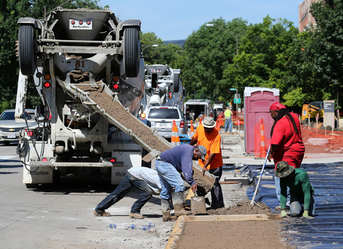 Workers pour sidewalk on Osborn Drive
