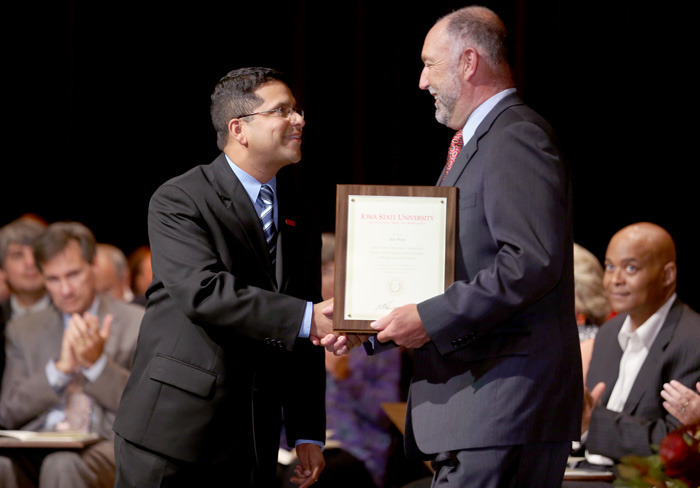 Faculty member Ajay Nair receives his award from President Steve