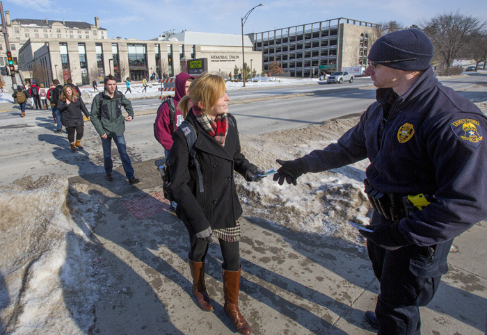 Ames police officer hands card to female student
