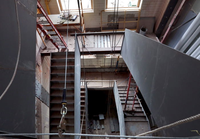 Steel stairs under construction in the original stairwell