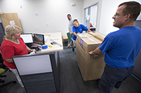 Movers bring in boxes to office