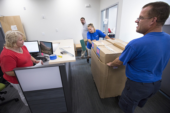 Crew moves a pallet of packed boxes into new office