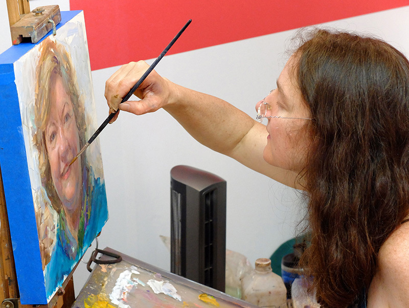 Female artist finishes up acrylic portrait