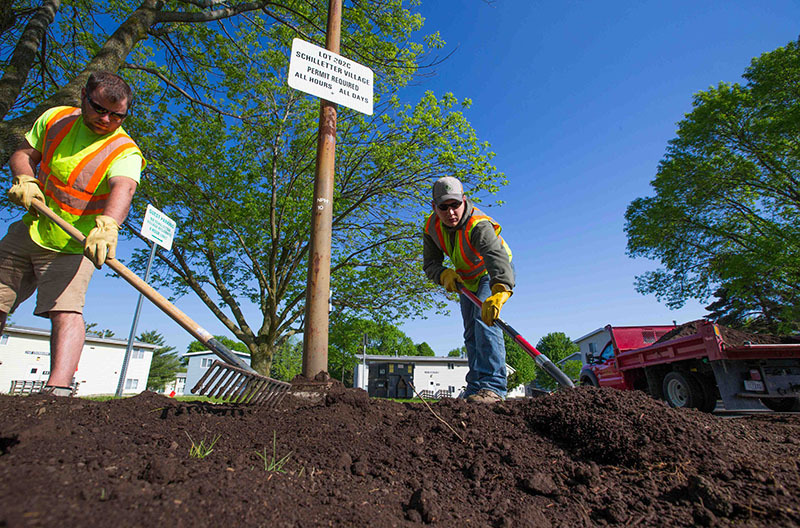 Grounds crews distributing compost on campus.