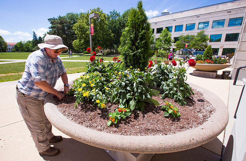 woman prepares soil in oversize planter