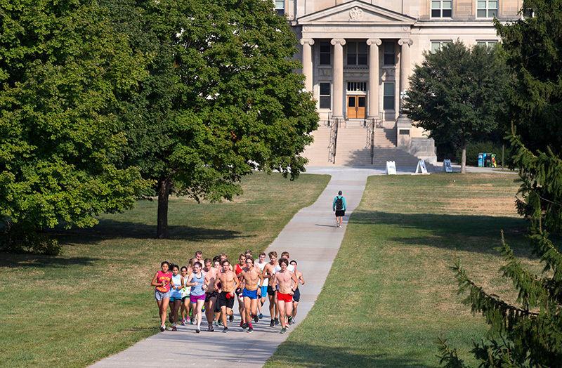 student runners cross central campus