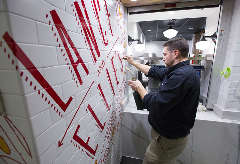 Installing signage at Lance and Ellie's deli