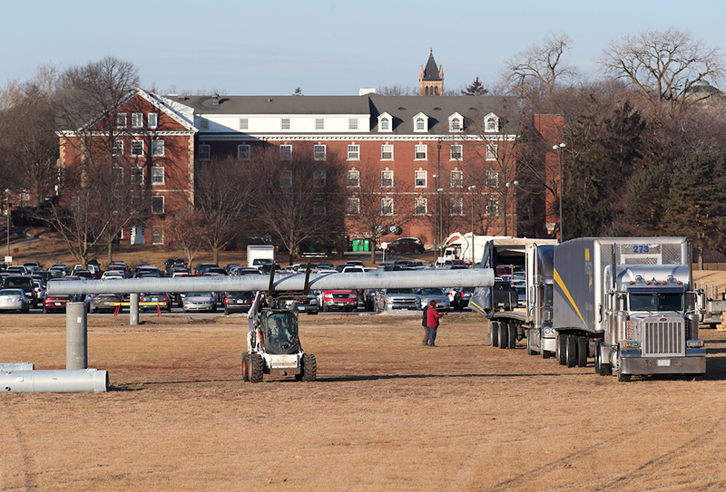 crews unload steel lightpoles from a semi truck