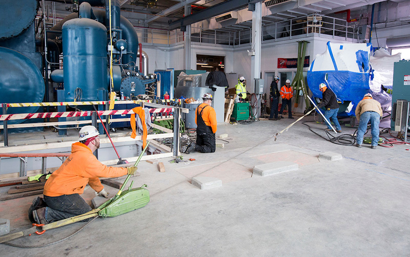 A cable and wench help guide the condenser cylinder to its spot 