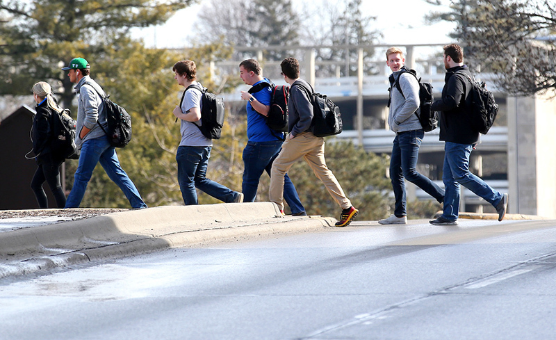 Male students cross a Lincoln Way median