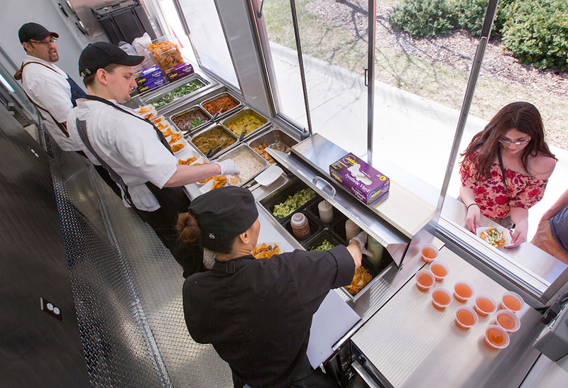 Employees prepare walking tacos inside Dinkey's grub truck