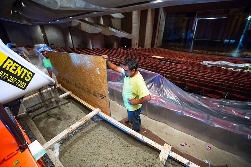 Two men pour concrete in Stephens to create a platform