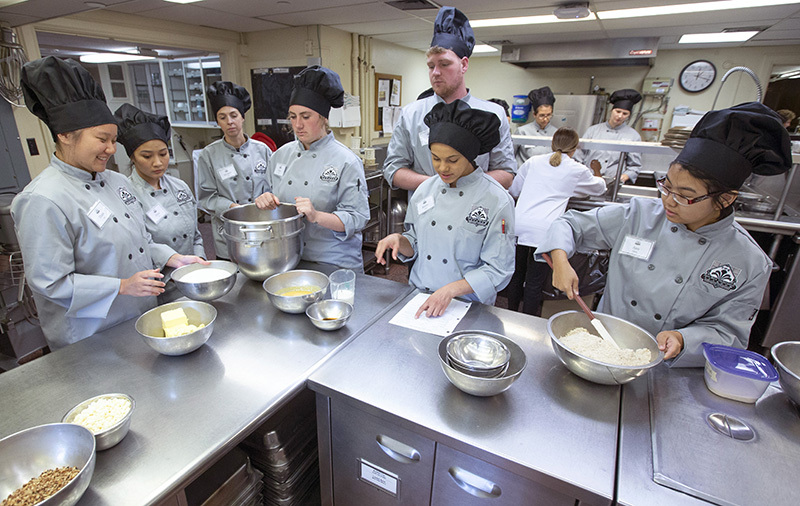 Students prepare food in the tearoom kitchen.