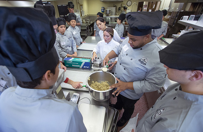 Students prepare food in the tearoom kitchen.