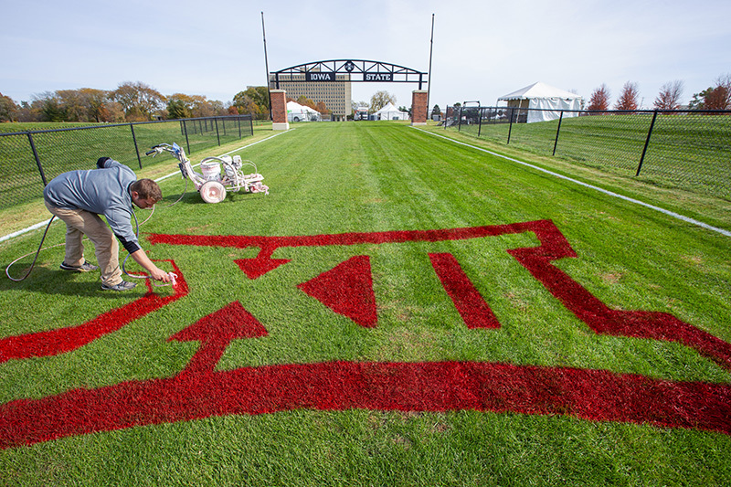 Conference logo being painted on the cross country course.