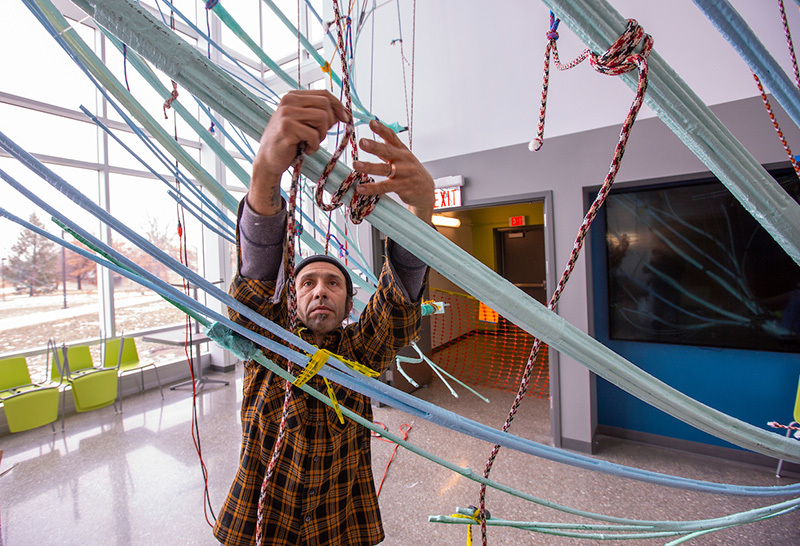 Artist Gaston Nogues ties a rope knot