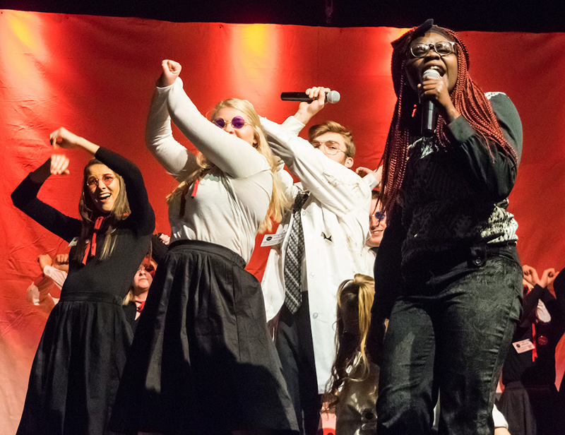 Students sing and dance on stage