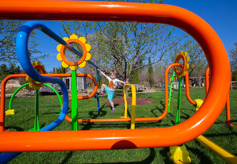 Toddler plays at BEEd Maze sculpture at Reiman Gardens