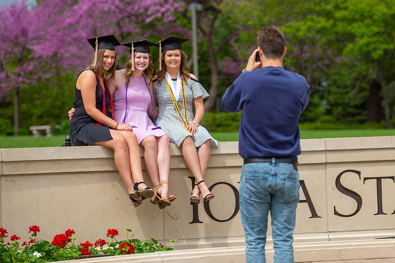Three female graduating students have their photo taken at the u