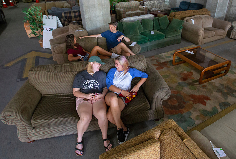 Female students sit on a couch to test for comfort