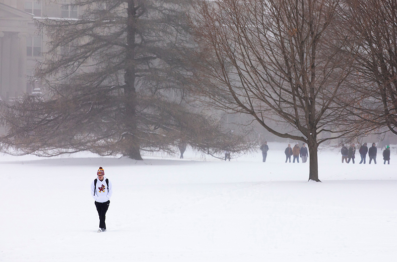 Male student crosses a snowy central campus
