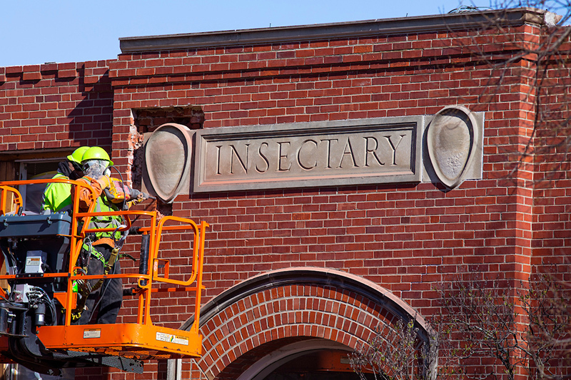 Workers carve out the Insectary nameplate for safe-keeping
