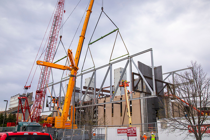 Two cranes lift the truss into place