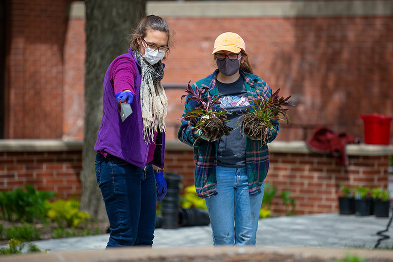 Lilah Anderson and Ellen Sattler confer on where to plant