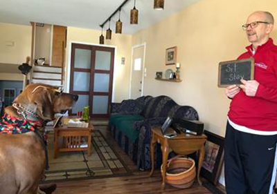 Man with chalkboard instructs his dog