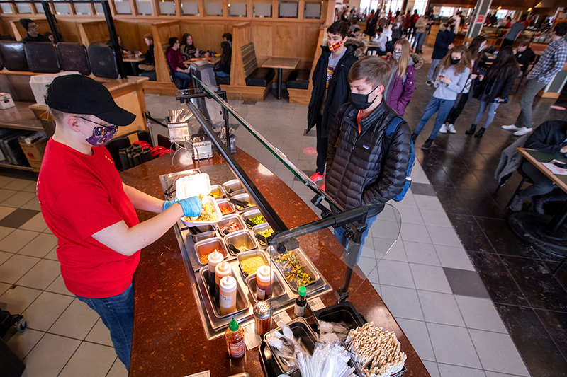 Caleb Myers prepares a rice bowl to go for Seth Larson