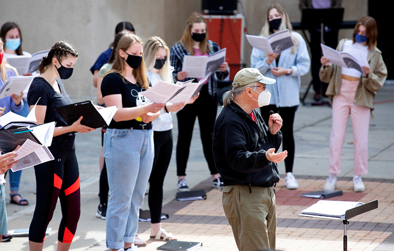 Female members of the Iowa State Singers rehearse outdoors