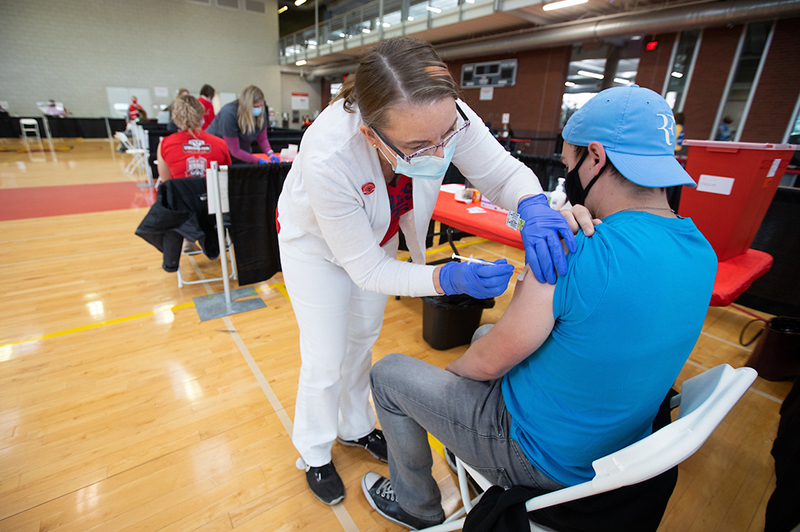 Dr. Margaret Evans administers a vaccine to student Ivan Rasmuss