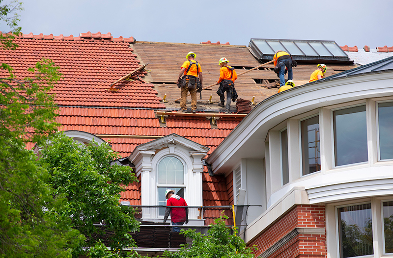 Crews replace the tile roof, in sections, on Enrollment Services