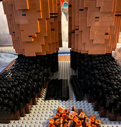 Black and brown LEGOs form shoes and pant legs