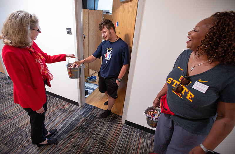 President Wintersteen and senior VP Younger greet male student i